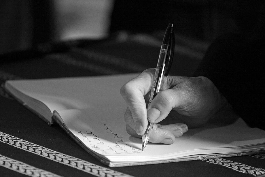 Linkshänder schreibt handschriftliches Testament mit der rechten Hand.